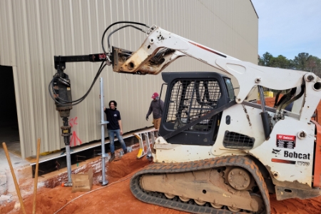 Installation of industrial helical piers by MDH Foundation Repair technicans